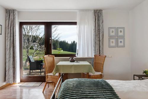 a bedroom with a table and chairs and a window at Haus Janßen-Wehrle in Titisee-Neustadt
