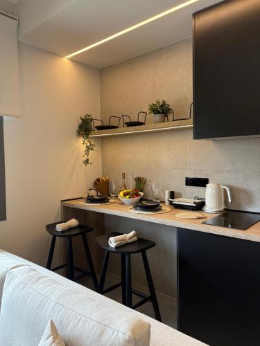 a kitchen with a counter and stools in a room at Maya Suites Potidaia in Nea Potidaea
