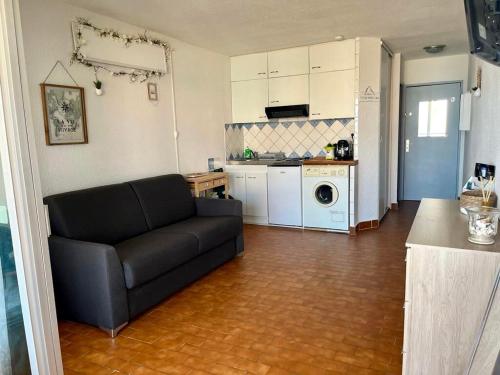 un salon avec un canapé et une cuisine dans l'établissement Bright studio with sea view, au Barcarès