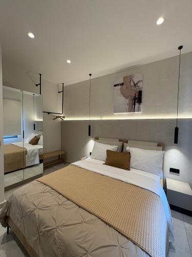 a bedroom with a large bed and a mirror at Maya Suites Potidaia in Nea Potidaea