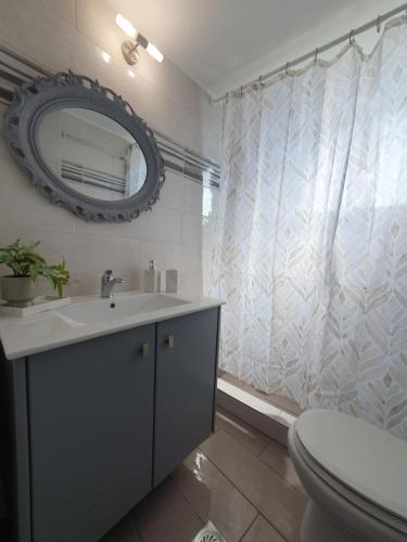 a bathroom with a sink and a toilet and a mirror at Aeon Blue in Sikinos