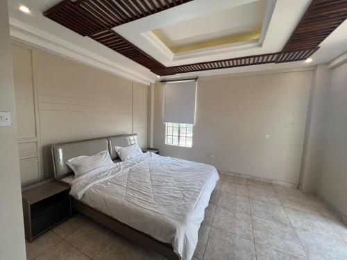 a bedroom with a bed with a coffered ceiling at Cosy 2 bedroom apartment in Arusha