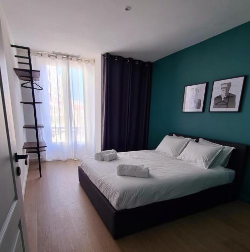 une chambre avec un grand lit avec un mur bleu dans l'établissement 2 Bedrooms 5 min walk to Croisette, à Cannes
