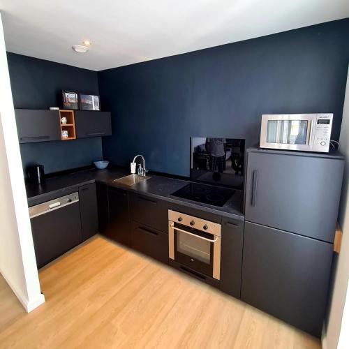 - une cuisine équipée de comptoirs noirs et d'un four micro-ondes blanc dans l'établissement 2 Bedrooms 5 min walk to Croisette, à Cannes