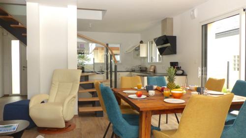 une salle à manger et un salon avec une table et des chaises dans l'établissement Confortable maison proche du centre-ville - Etel, à Étel