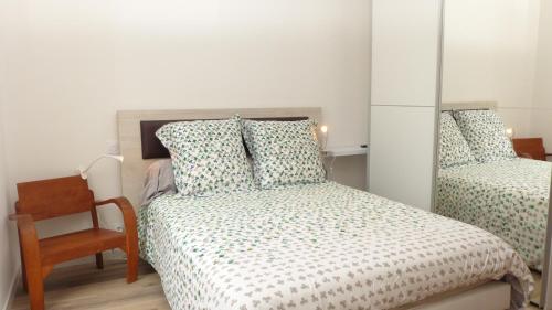 une petite chambre avec un lit et une chaise dans l'établissement Confortable maison proche du centre-ville - Etel, à Étel