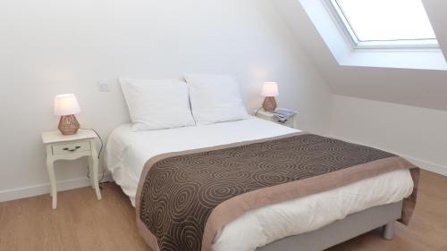 - une chambre avec un lit et deux lampes sur les tables dans l'établissement Ty Eglantines - confortable maison neuve proche des plages, à Étel