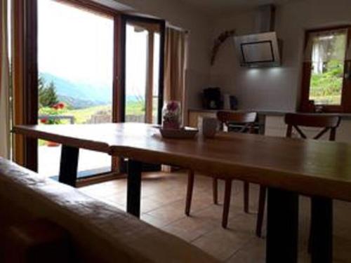 a wooden table in a living room with a large window at Haus Berglust Wallgau in Wallgau