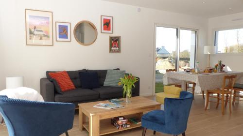 un salon avec un canapé et une table dans l'établissement Ty Eglantines - confortable maison neuve proche des plages, à Étel