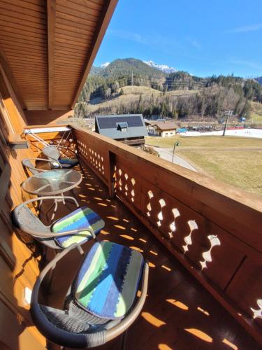 a balcony with chairs and tables and a view of a field at Komfort Appartement Royal Windberger in Schladming