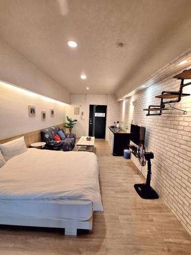 ein Schlafzimmer mit einem weißen Bett und einer Ziegelwand in der Unterkunft Moonlight 大陽台溫泉宿 in Jiaoxi