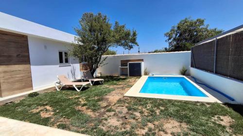 Un patio trasero con piscina y una casa. en Passive House con piscina y jardín privado, en Novo Sancti Petri
