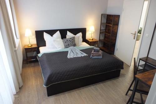 a bedroom with a bed and two tables and two lamps at Pension Markgrafenmühle in Cottbus