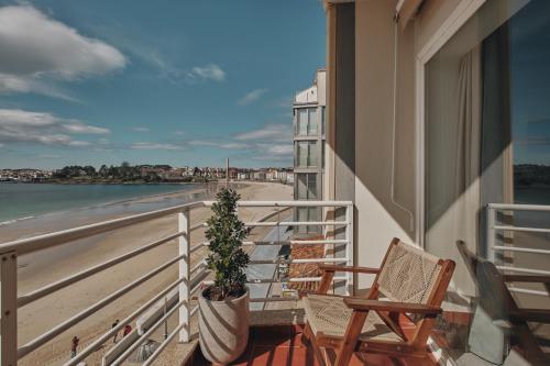 サンシェンショにあるHotel Atlante Sanxenxo Boutiqueのビーチの景色を望むバルコニー(椅子2脚付)