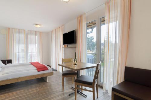 a bedroom with a bed and a desk with a table at Gästehaus D i c k r e i t e r in Immenstaad am Bodensee