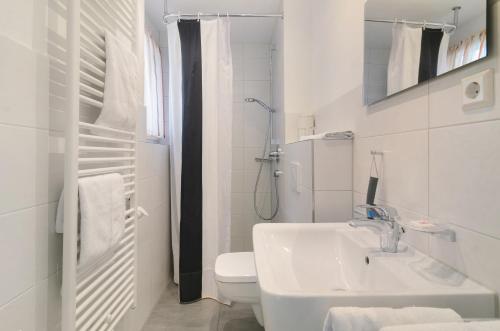 a white bathroom with a sink and a toilet at Gästehaus D i c k r e i t e r in Immenstaad am Bodensee