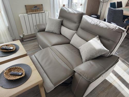 - un canapé en cuir installé à côté d'une table basse dans l'établissement Mon petit paradis - Proche de la mer et Touquet, à Camiers