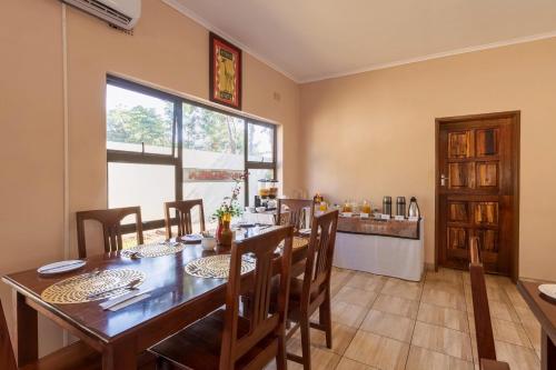 a dining room with a wooden table and chairs at Victoria Falls Premier Lodge in Victoria Falls
