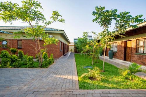 a brick building with a walkway in a yard at Victoria Falls Premier Lodge in Victoria Falls