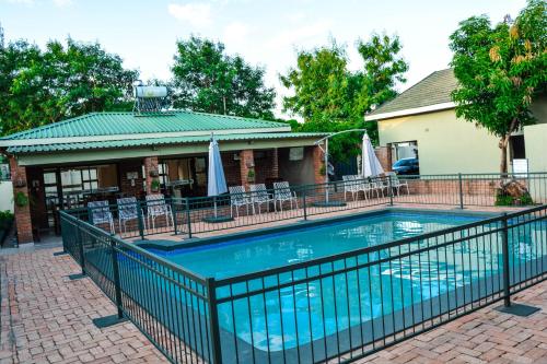 a swimming pool with a fence around it at Victoria Falls Premier Lodge in Victoria Falls
