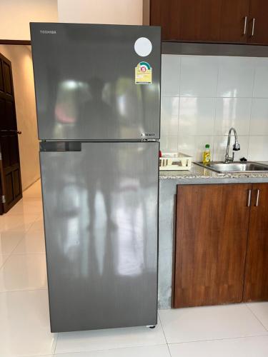 a stainless steel refrigerator in a kitchen at Nern khao Guesthouse in Kamala Beach