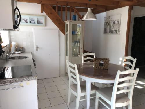 eine Küche mit einem Tisch und Stühlen in einer Küche in der Unterkunft Villa OCELANDES in Saint-Julien-en-Born