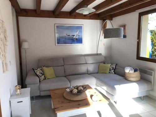 ein Wohnzimmer mit einer Couch und einem Tisch in der Unterkunft Villa OCELANDES in Saint-Julien-en-Born