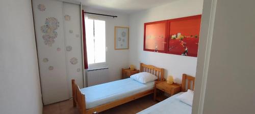 une petite chambre avec deux lits et une fenêtre dans l'établissement Maison confortable à Torreilles avec jardin privé, à Torreilles