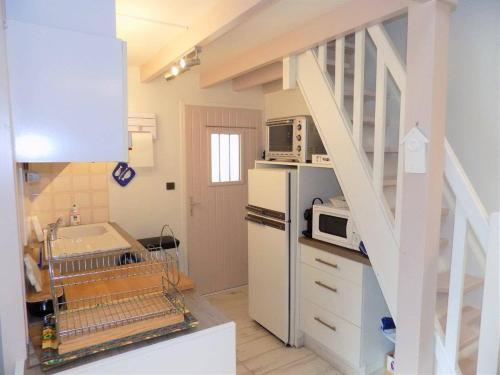 La cuisine est équipée d'un réfrigérateur blanc et d'un four micro-ondes. dans l'établissement Saint Georges de Didonne - RAVISSANTE VILLA en RESIDENCE à 150m de la Plage, à Saint-Georges-de-Didonne