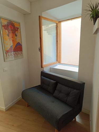 a couch in a room with a window at Castle apartment Aga in Uzzano