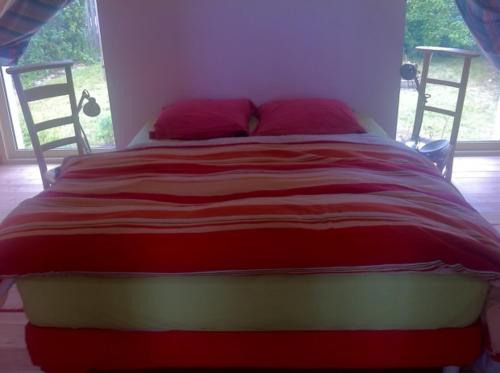 łóżko w sypialni z czerwonym i białym kocem w obiekcie L'Atelier w mieście Wissant