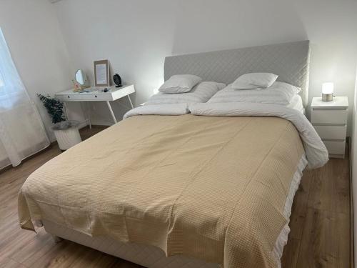a bedroom with a large bed and a desk at SpaGo Apartment in Hajdúszoboszló