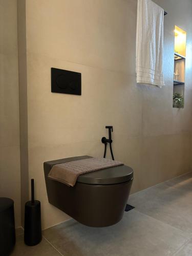a bathroom with a black toilet in a room at Maya Suites Potidaia in Nea Potidaea