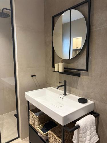 a bathroom with a white sink and a mirror at Maya Suites Potidaia in Nea Potidaea