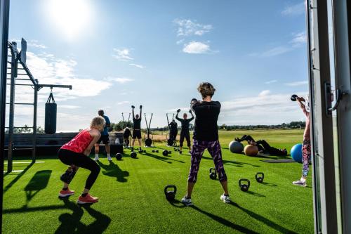 a group of people in a field playing with clubs at Halmstad Golfarena stugor in Halmstad