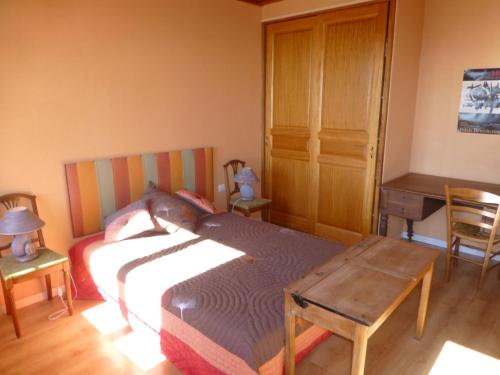 une chambre avec un lit, un bureau et une table dans l'établissement Gîte belle Rîve, à Vauville