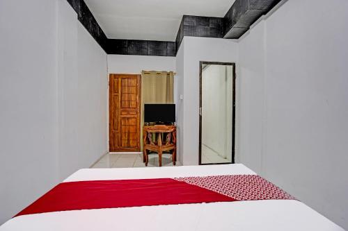 a bedroom with a bed and a desk at Hotel O Villa A1 in Tretes