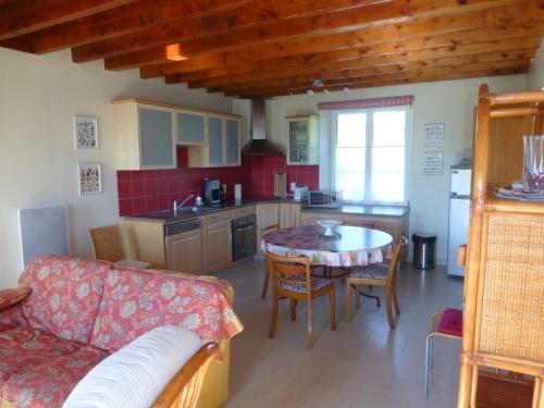une cuisine et un salon avec une table et un canapé dans l'établissement Gîte belle Rîve, à Vauville