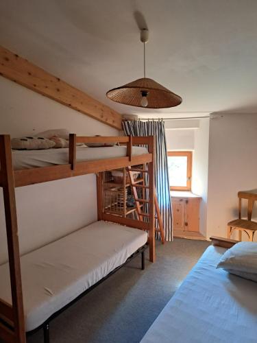 une chambre avec deux lits superposés et une lampe dans l'établissement Grande et confortable maison familiale et sa source !, à Eygluy