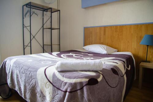 a bedroom with a bed with two towels on it at Hotel Durand Le Patio in Alès