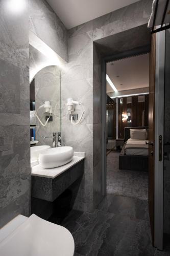 a bathroom with a sink and a toilet and a bed at Merida Hotel Baku in Baku