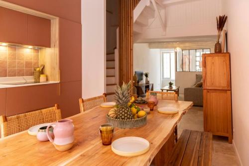 - une grande table en bois avec des fruits dans la cuisine dans l'établissement Maison Zellige - Rooftop - Gruissan Center, à Gruissan