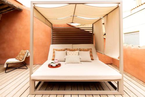 a bed on a balcony with a canopy at Maison Zellige - Rooftop - Gruissan Center in Gruissan