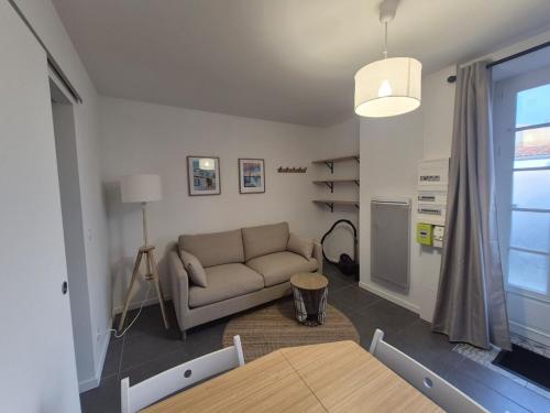 a living room with a couch and a table at Mooney, 2 rooms, Wi-Fi, Garden Terrace in La Rochelle