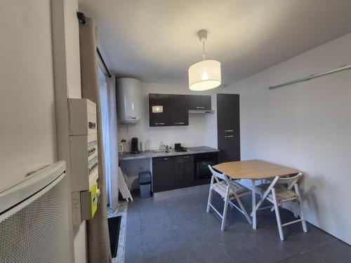 a small kitchen with a table and chairs in a room at Mooney, 2 rooms, Wi-Fi, Garden Terrace in La Rochelle