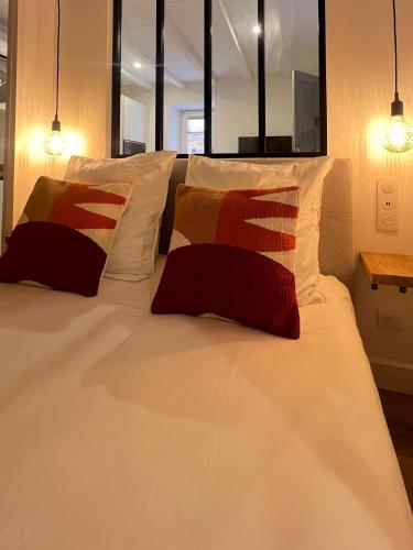 un grand lit blanc avec deux oreillers dessus dans l'établissement Appartement citadelle Bonifacio Appolonie, à Bonifacio