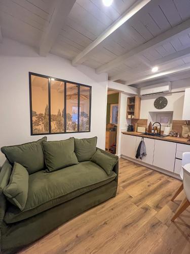 un salon avec un canapé vert et une cuisine dans l'établissement Appartement citadelle Bonifacio Appolonie, à Bonifacio
