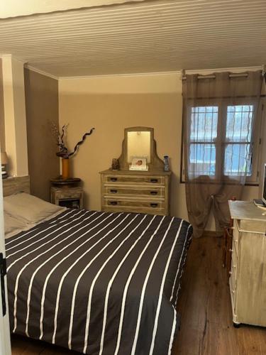 une chambre avec un lit, une commode et un miroir dans l'établissement Maison de Village, à Gémenos