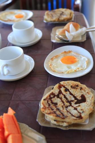 uma mesa de madeira coberta com pratos de comida de café da manhã em Sanlota Resort em Habaraduwa Central