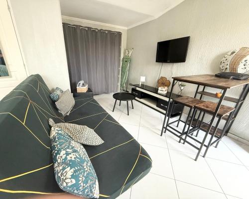 un salon avec un canapé et une table dans l'établissement Fully equipped studio with garden, à Pessac